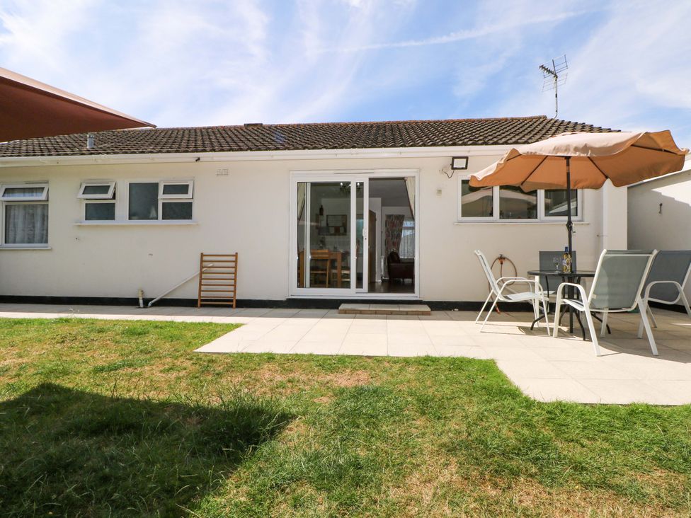A garden with patio furniture at Dymchurch Bungalow in Romney Marsh
