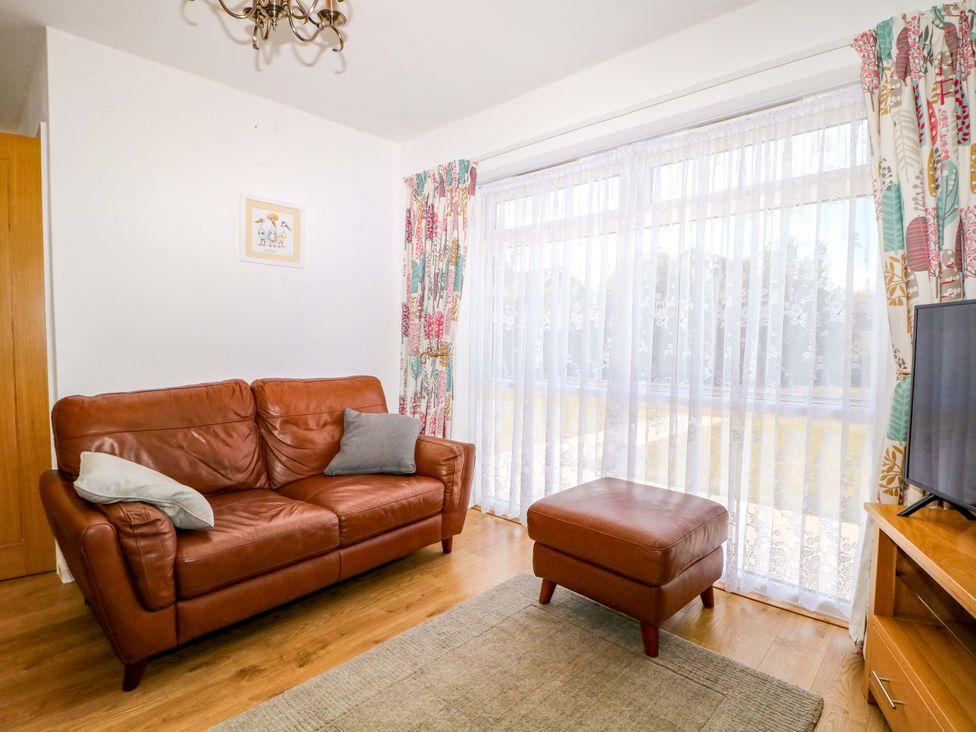 A living room with a sofa and television at Dymchurch Bungalow in Romney Marsh
