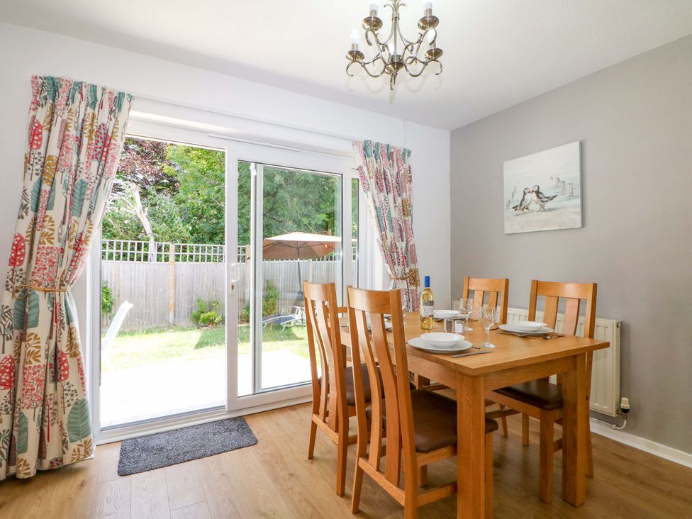 A dining room with a table and chairs at Dymchurch Bungalow in Romney Marsh