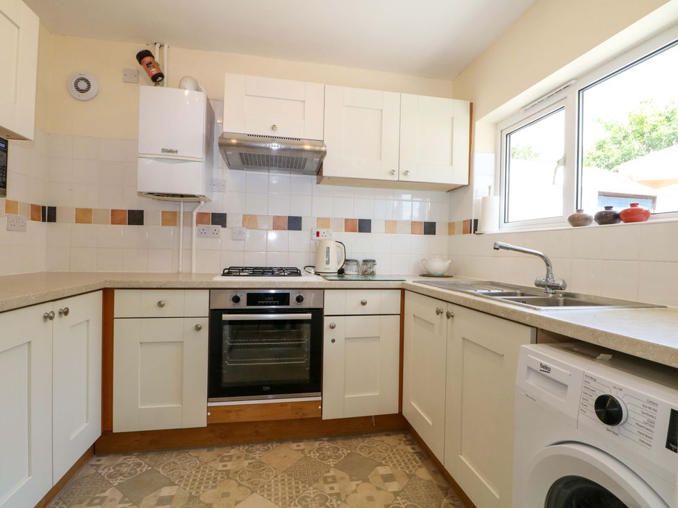A kitchen with an oven, stove, and sink at Dymchurch Bungalow in Romney Marsh