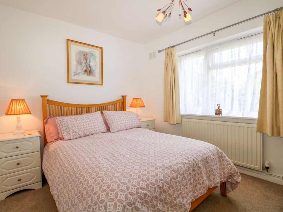 A bedroom with a bed and bedside lamps at Dymchurch Bungalow in Romney Marsh