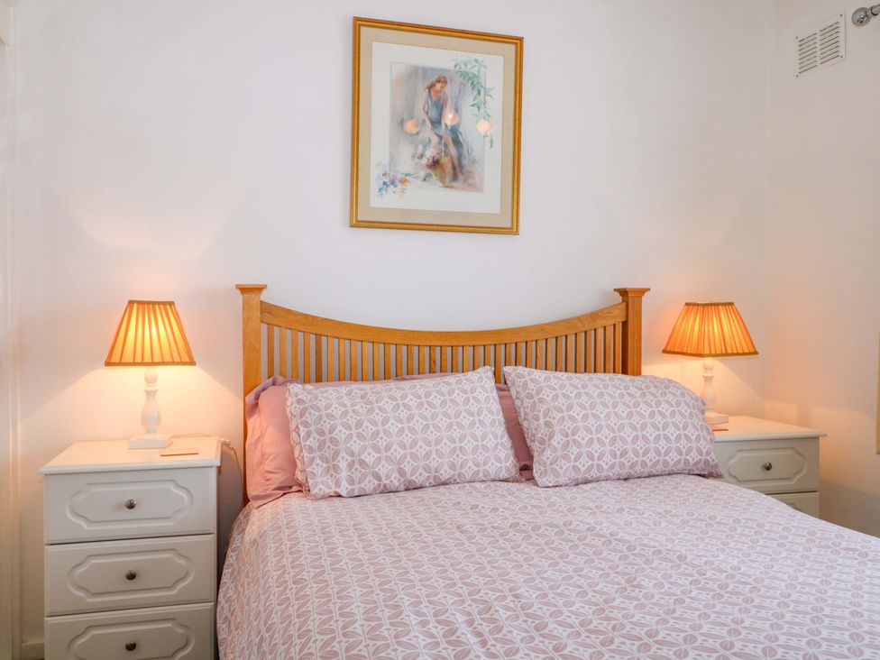 A bedroom with a bed and bedside tables at Dymchurch Bungalow in Romney Marsh