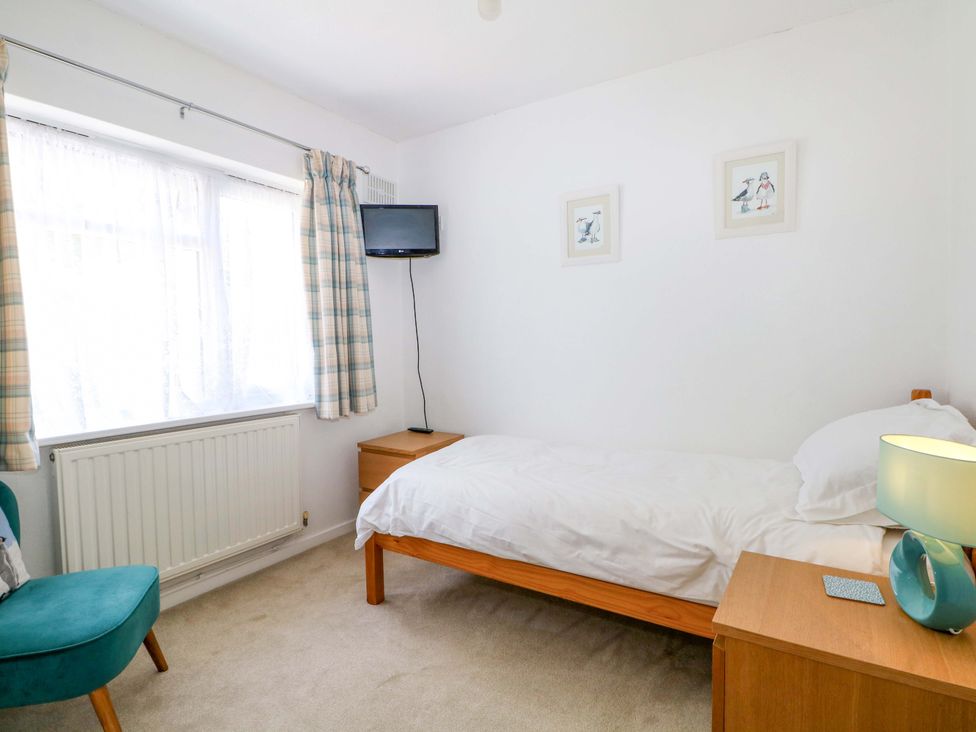 A bedroom with a bed and TV at Dymchurch Bungalow in Romney Marsh