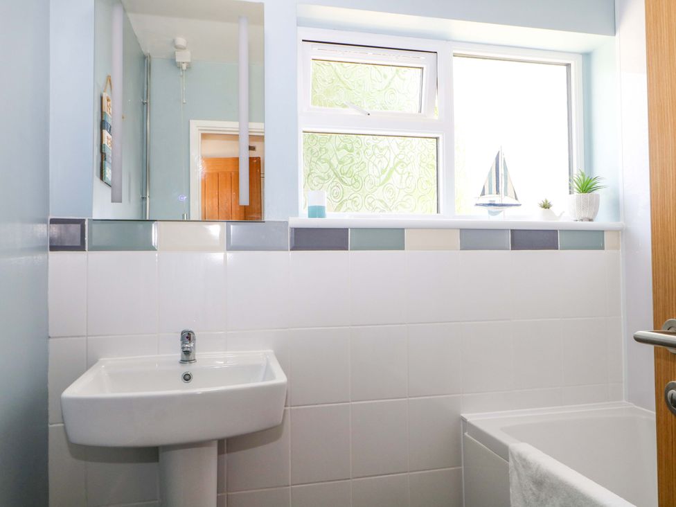 A bathroom with a sink and a window at Dymchurch Bungalow in Romney Marsh