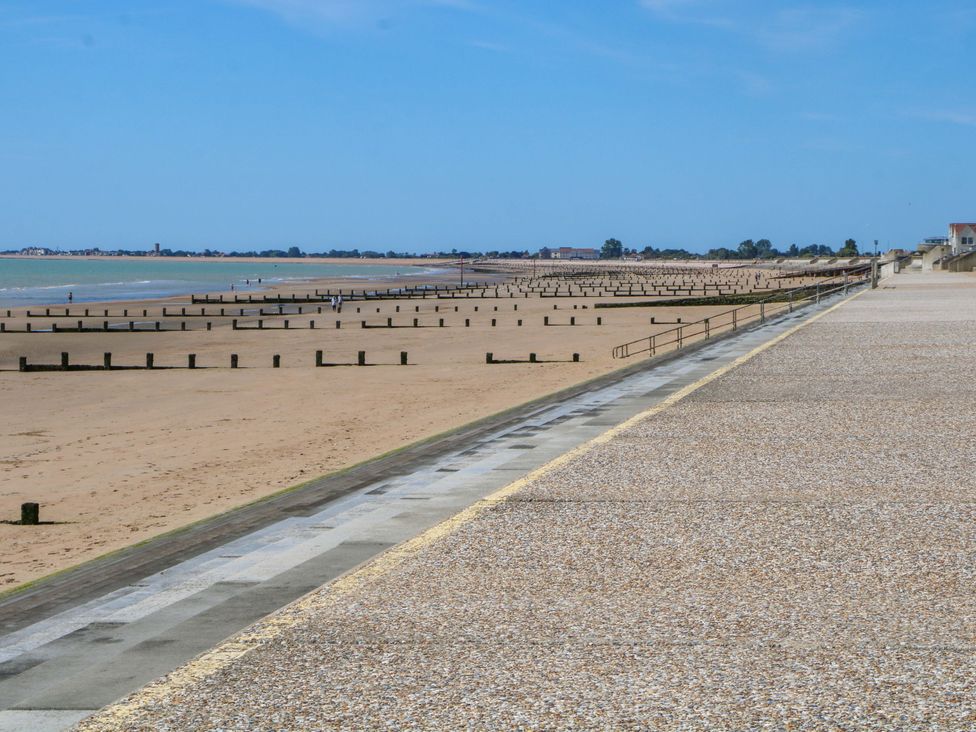 A beach view with sand and poles at Dymchurch Bungalow in Romney Marsh