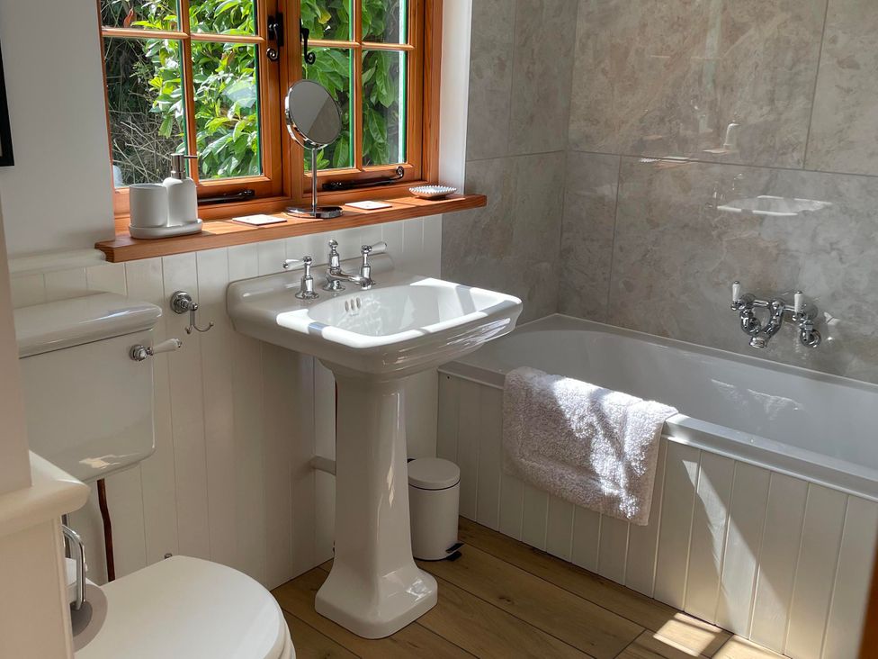 A bathroom featuring a bathtub, sink, and toilet at Bell Buoy Cottage Morwenstow