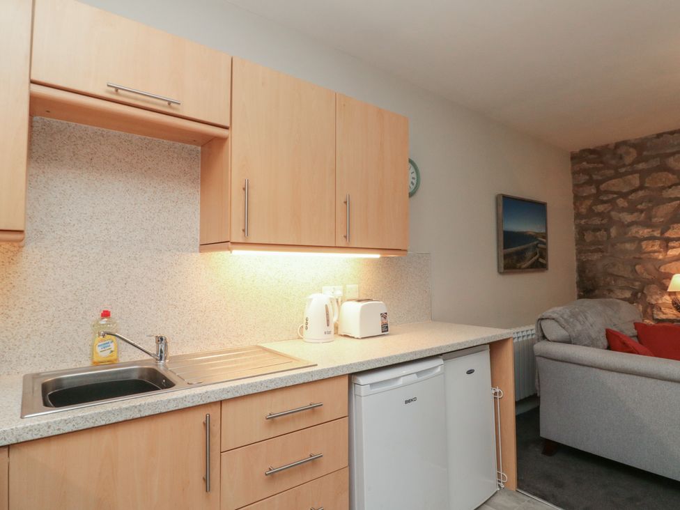A kitchen with a sink, cabinets, and appliances at Beck View