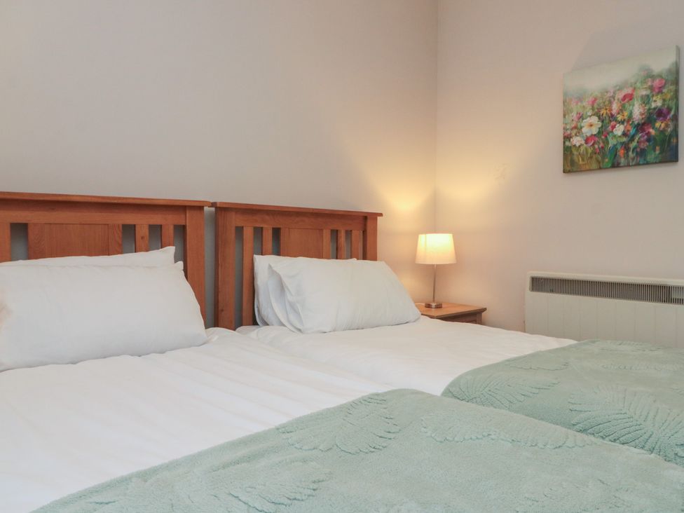 A bedroom with two beds and a bedside lamp at Beck View