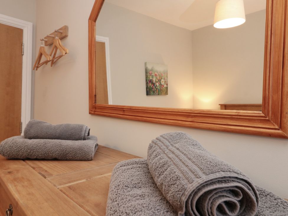 A bathroom with towels on a table and a mirror at Beck View