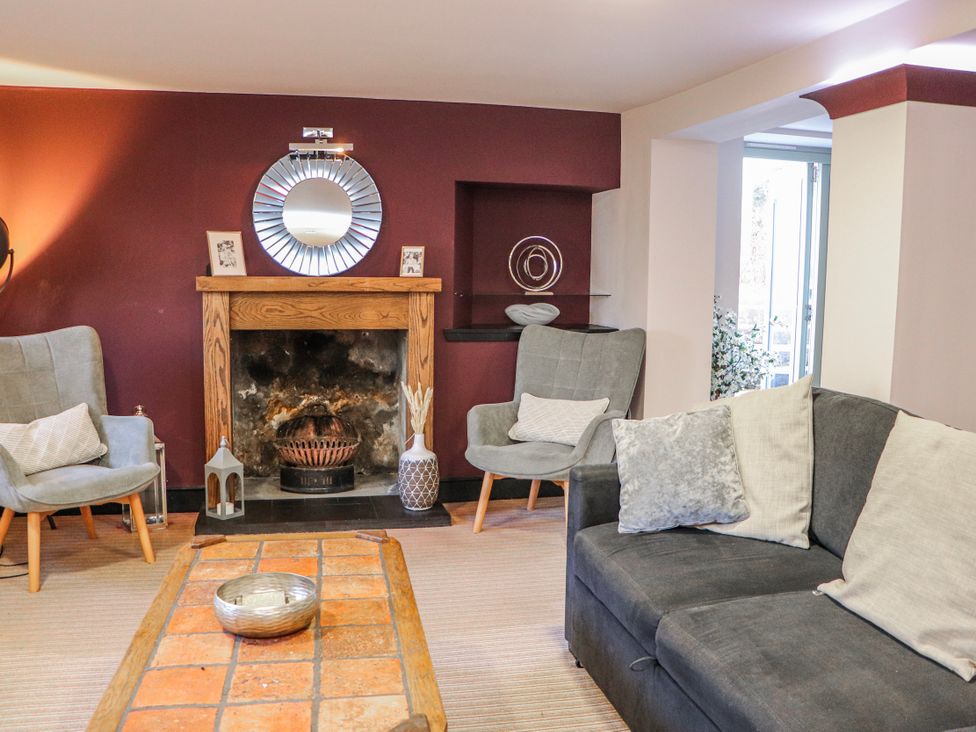 A living room with a fireplace and seating at Mary Ann Apartment Inverness