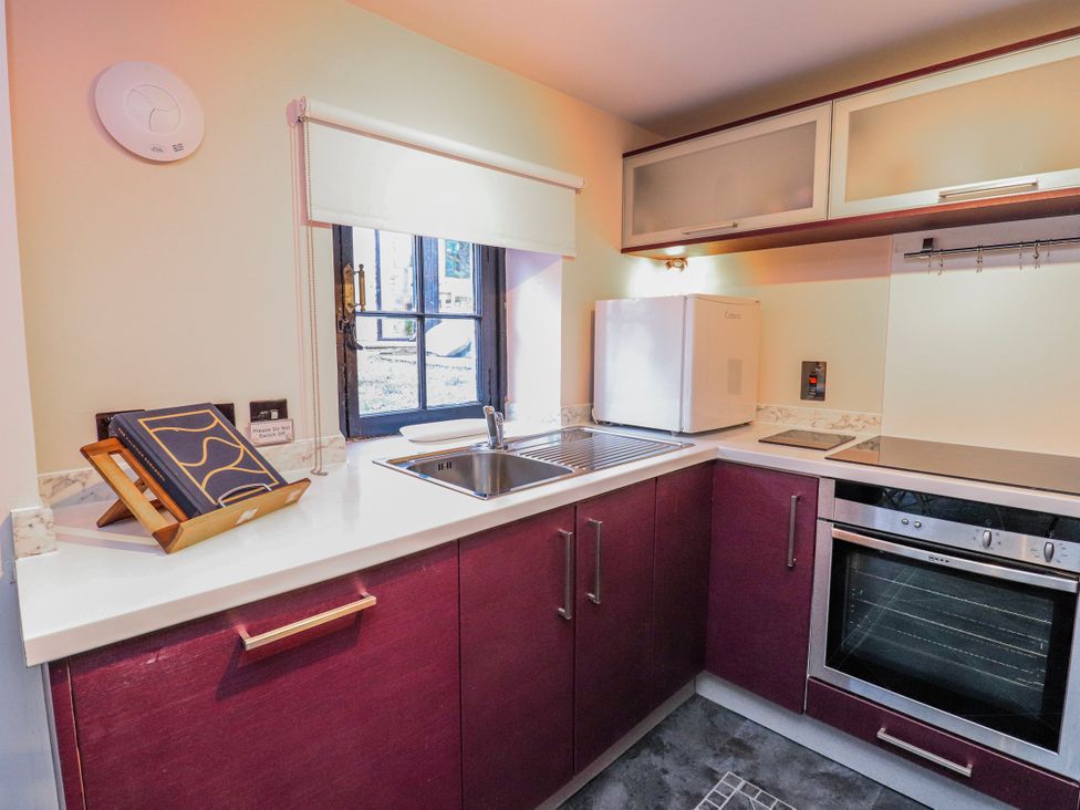 A kitchen with a sink and refrigerator at Mary Ann Apartment in Inverness