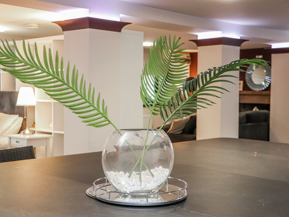 A table with a vase of leaves at Mary Ann Apartment in Inverness