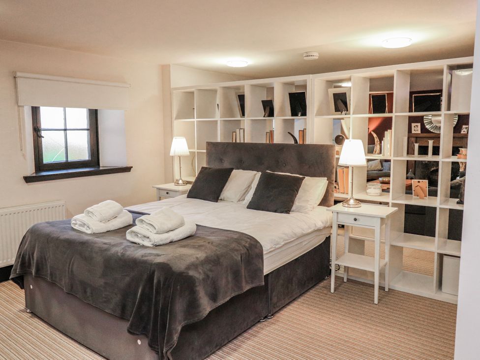 A bedroom with a bed and a bookshelf at Mary Ann Apartment in Inverness