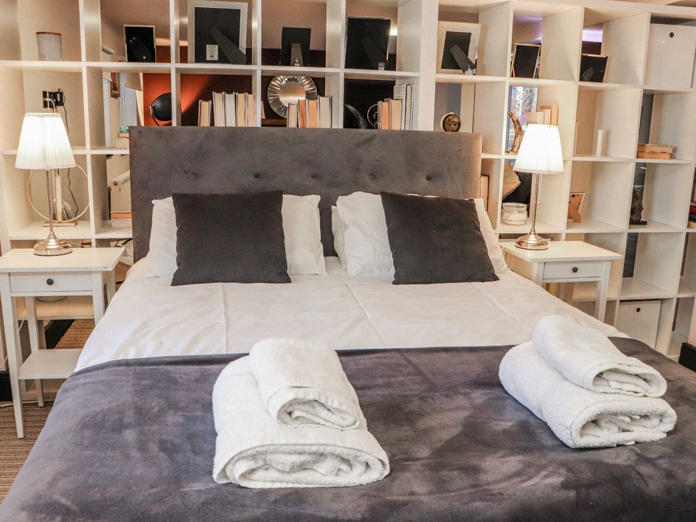 A bedroom with a bed and shelves at Mary Ann Apartment in Inverness