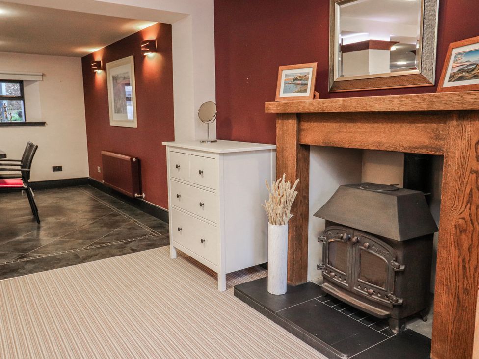 A living room with a fireplace and a drawer cabinet at Mary Ann Apartment in Inverness