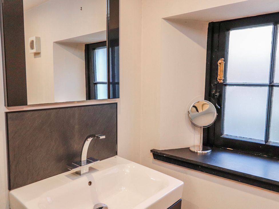 A bathroom with a sink and mirror at Mary Ann Apartment in Inverness
