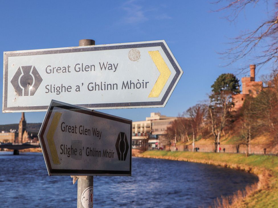 A sign for Great Glen Way beside a river at Mary Ann Apartment Inverness