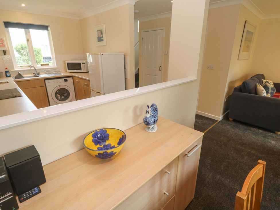 A kitchen with appliances and dining area at Pheasants Walk in Falmouth