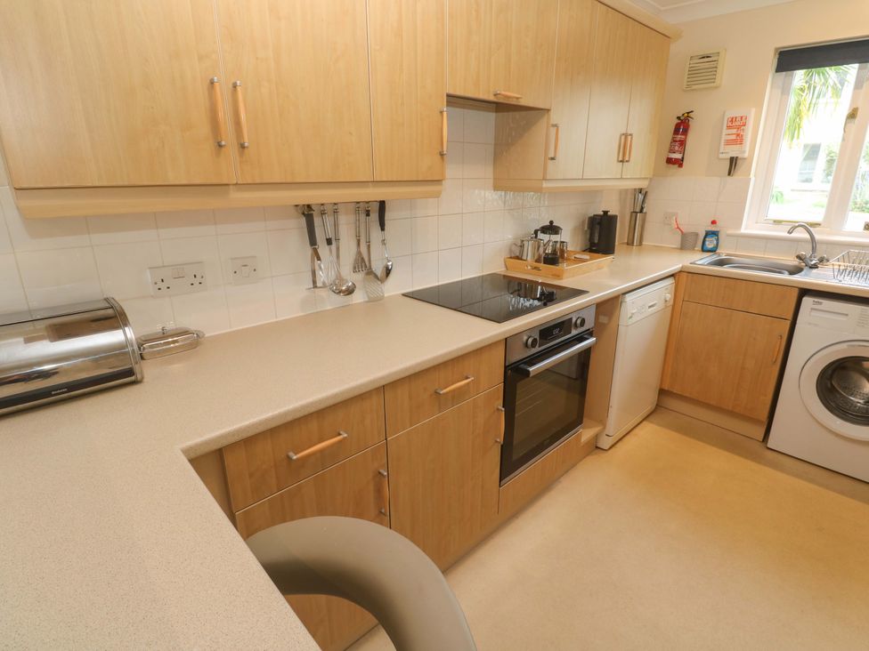 A kitchen with cabinets and appliances at Pheasants Walk in Falmouth