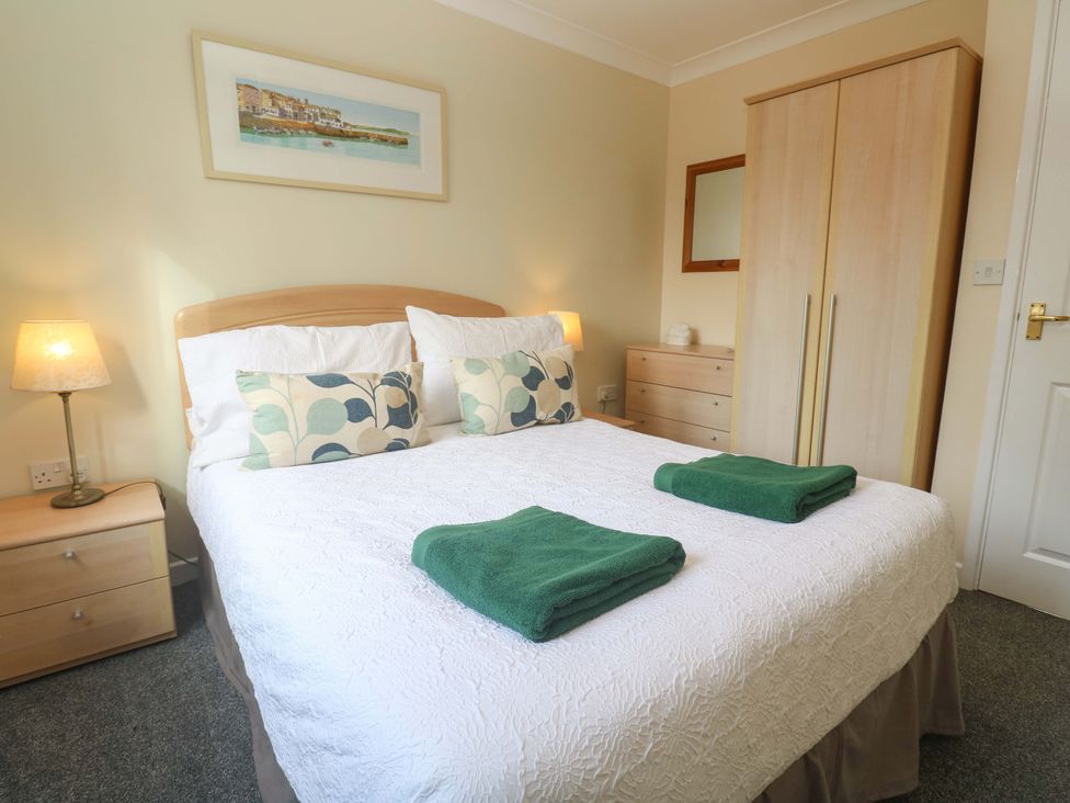 A bedroom with a bed and towels at Pheasants Walk in Falmouth