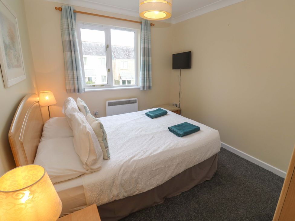 A bedroom with a bed and tv at Pheasants Walk in Falmouth