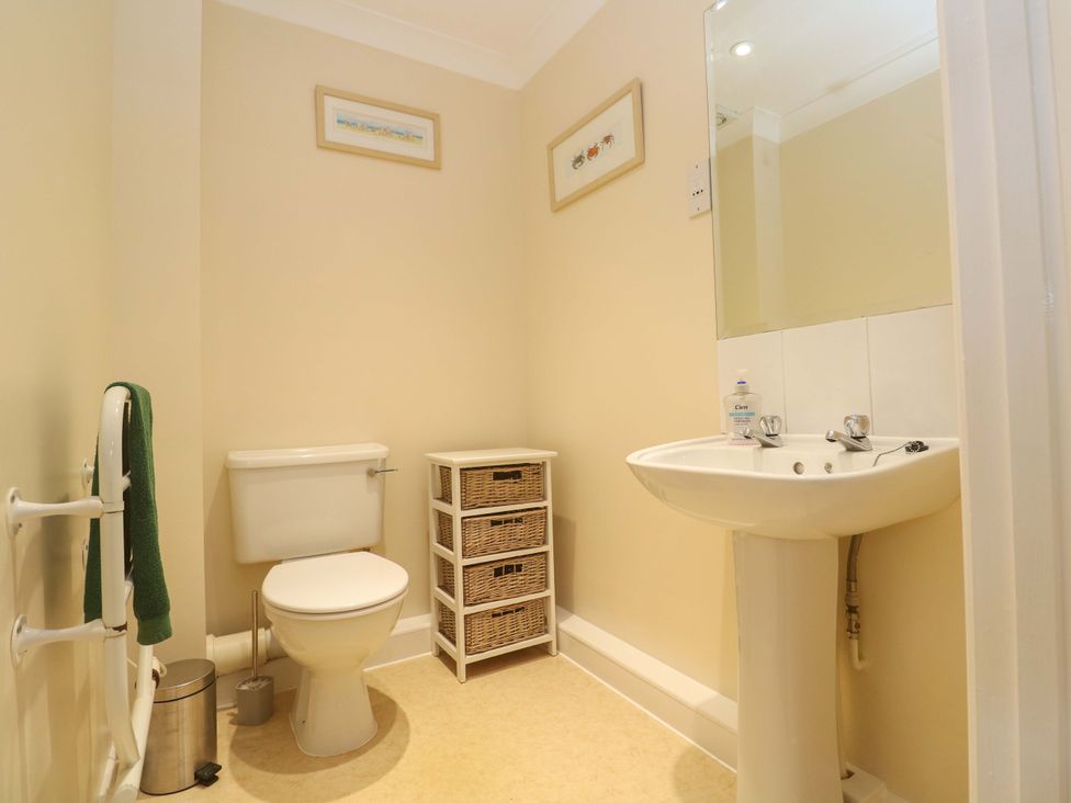 A bathroom with toilet, sink, and storage at Pheasants Walk in Falmouth