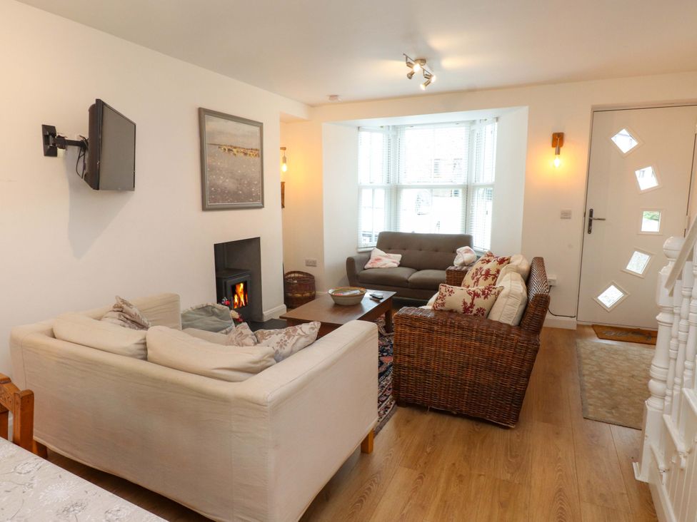 A living room with a fireplace and a TV at Bodefi in Nefyn