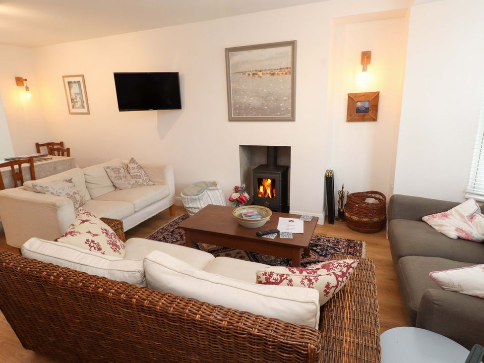 A living room with sofas, coffee table and a fireplace at Bodefi in Nefyn
