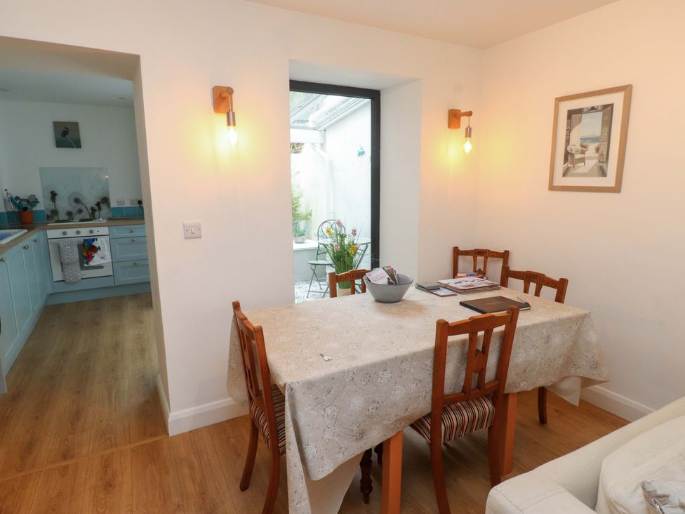 A dining room with wooden table and chairs at Bodefi in Nefyn