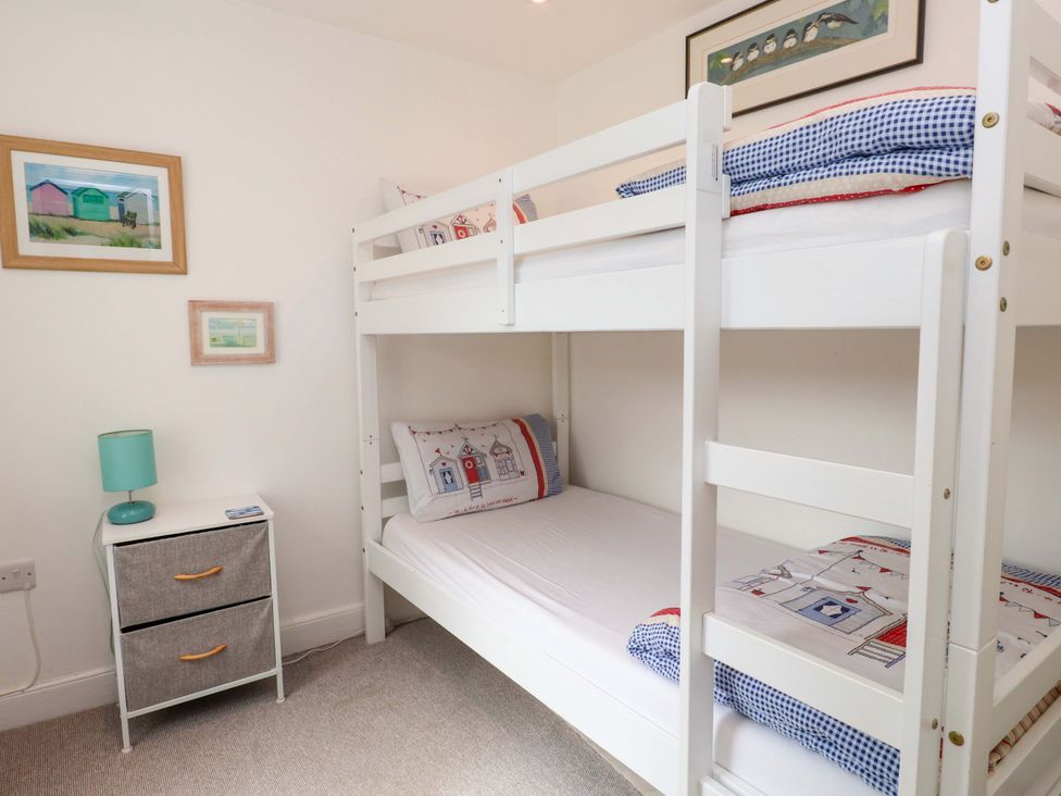 A bedroom with a bunk bed and nightstand at Bodefi in Nefyn