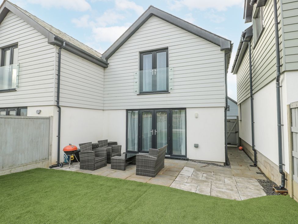 A garden with a patio and outdoor seating at Y Ty Pren in Brynteg near Benllech