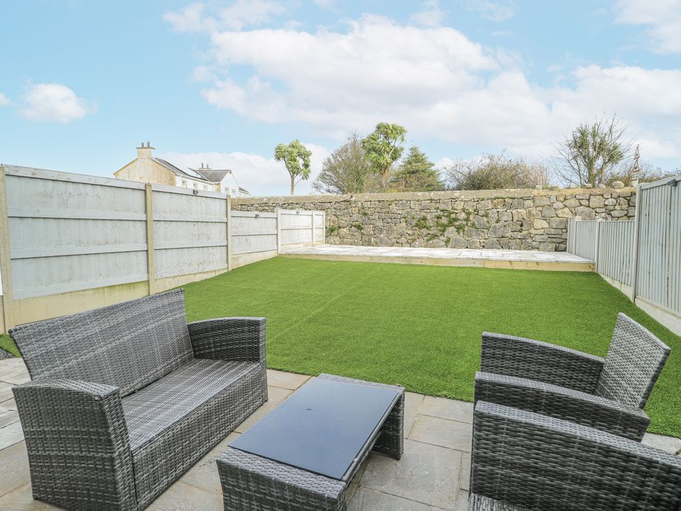A garden with a seating area and lawn at Y Ty Pren in Brynteg near Benllech