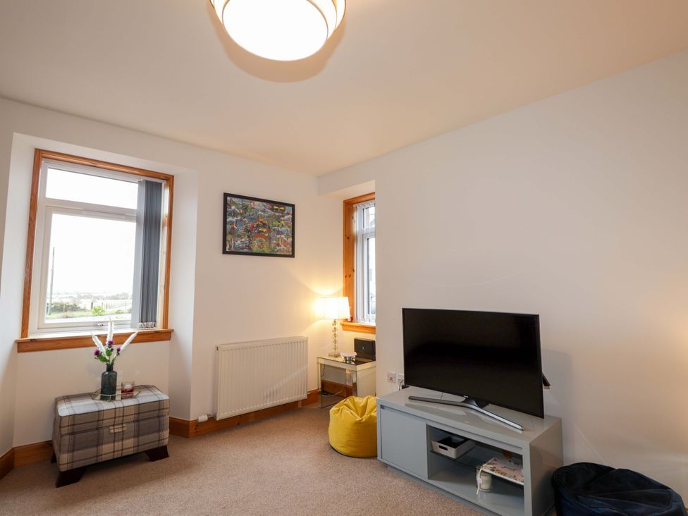 A living room with a television and coffee table at Nanville in Muir of Ord and Beauly