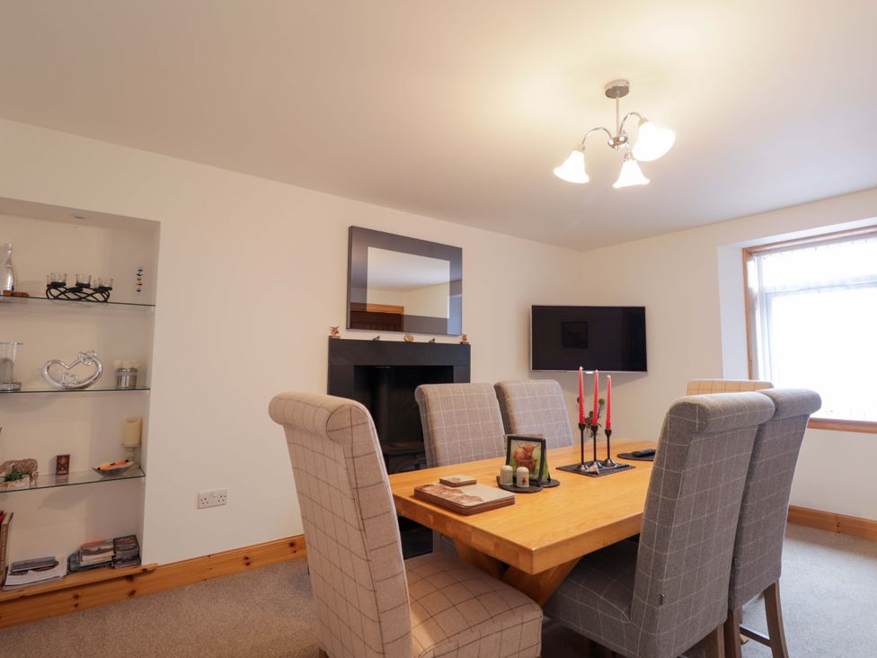 A dining room with a table and chairs at Nanville Muir of Ord and Beauly