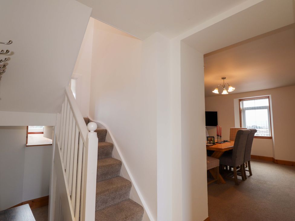 A dining room with a table and chairs at Nanville in Muir of Ord and Beauly