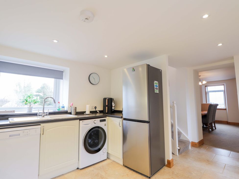 A kitchen with a sink and appliances at Nanville in Muir of Ord and Beauly