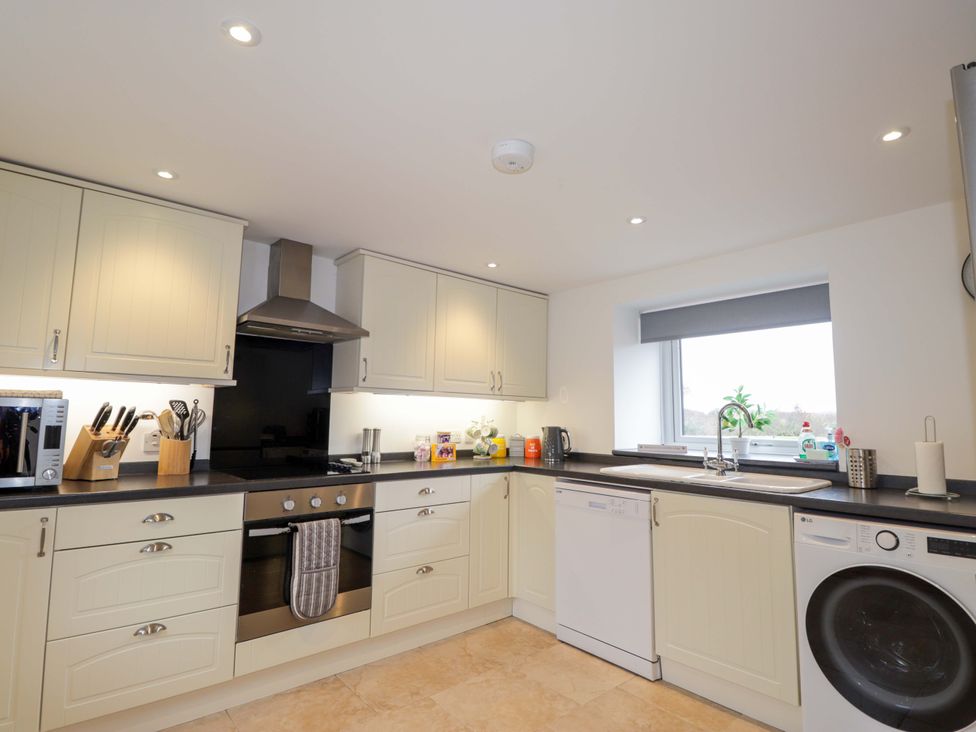 A kitchen with cabinets and appliances at Nanville in Muir of Ord and Beauly