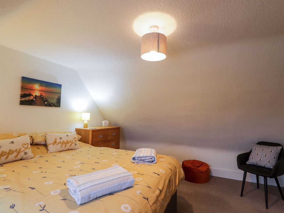 A bedroom with a bed and bedside lamp at Nanville in Muir of Ord and Beauly