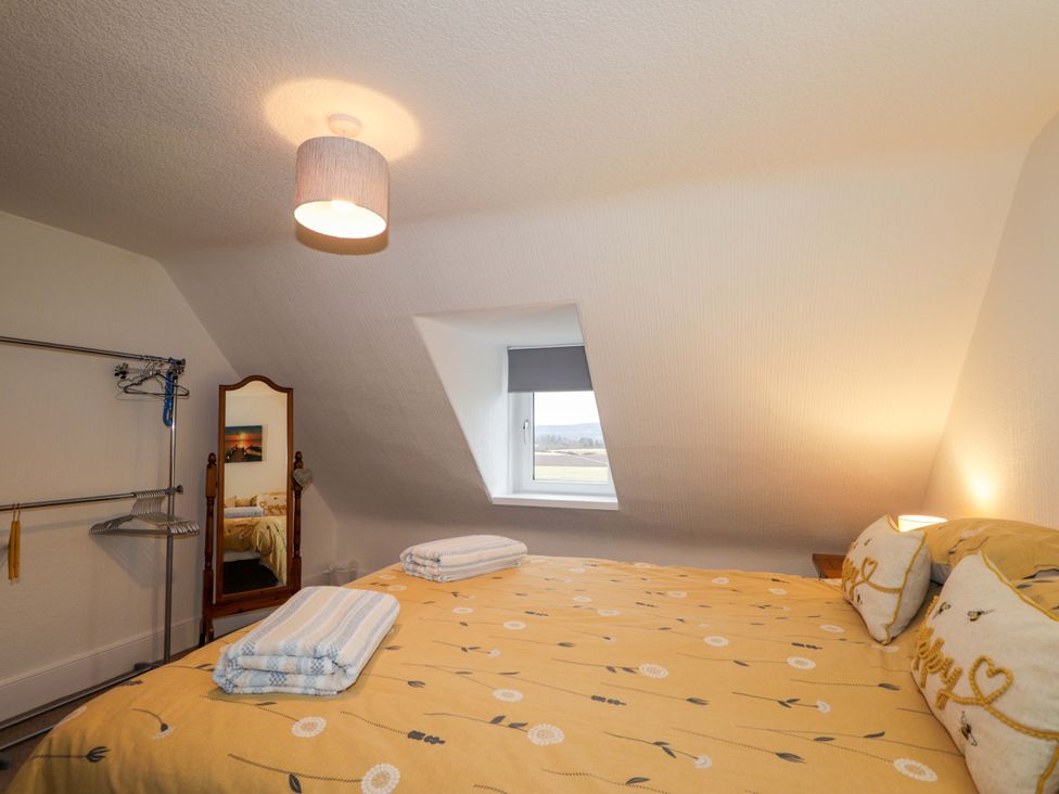 A bedroom with bed and mirror at Nanville in Muir of Ord and Beauly