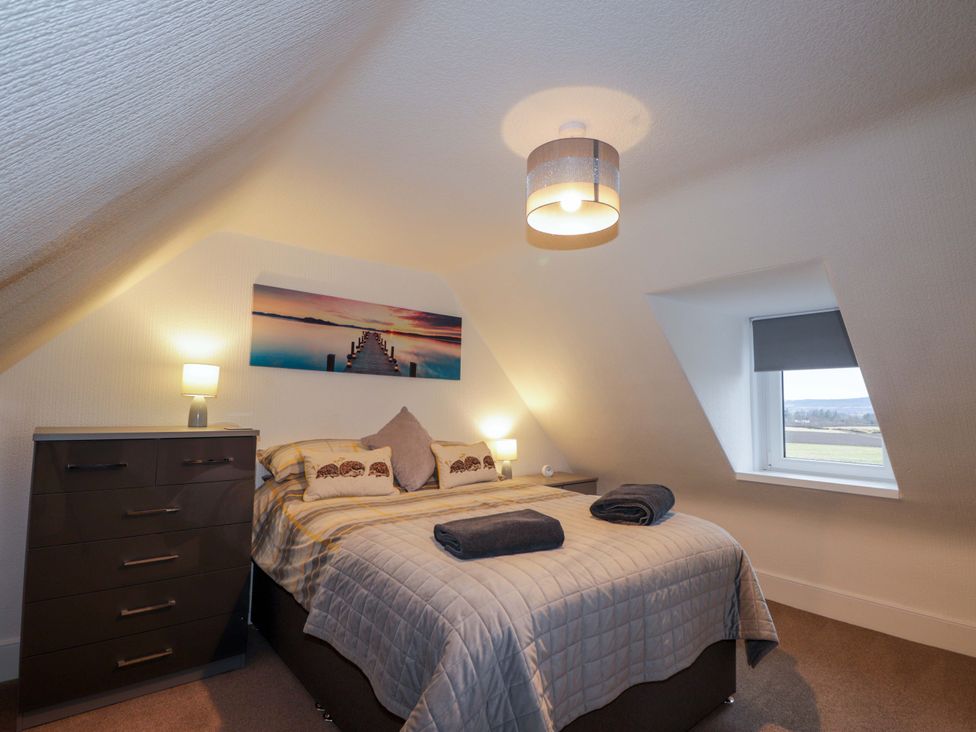 A bedroom with a bed and a dresser at Nanville in Muir of Ord and Beauly