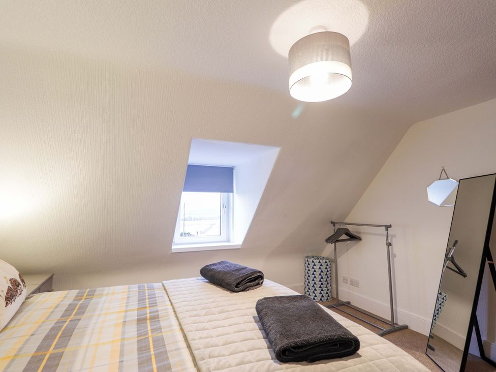 A bedroom with a bed and towels on it at Nanville in Muir of Ord and Beauly