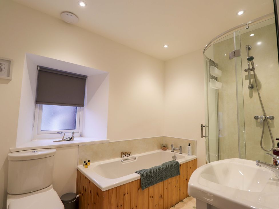 A bathroom with a bathtub and shower at Nanville in Muir of Ord and Beauly