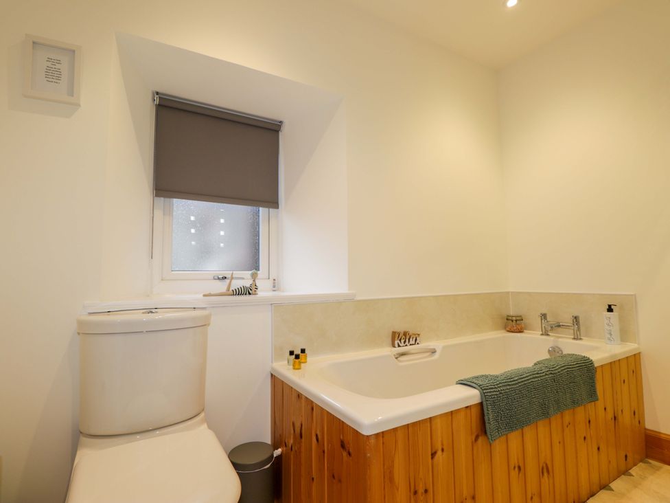 A bathroom with a bathtub and a toilet at Nanville in Muir of Ord and Beauly