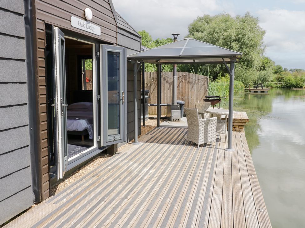 A deck area with a gazebo and seating at Oak Lodge At Bridge Lake Farm & Fishery Chacombe