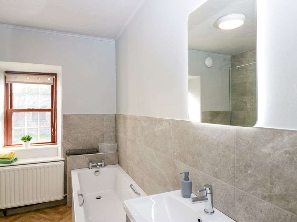 A bathroom with a bathtub and sink at Beckside Farm Bootle near Millom, Cumbria