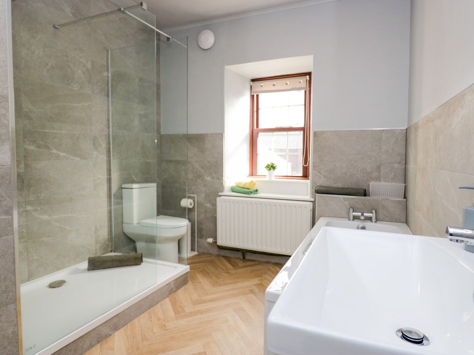 A bathroom with a shower, toilet, and bathtub at Beckside Farm in Bootle near Millom, Cumbria