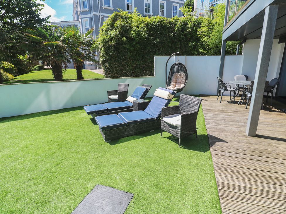 A garden with loungers and a hanging chair at Peninsula Apartment 2 in St Ives