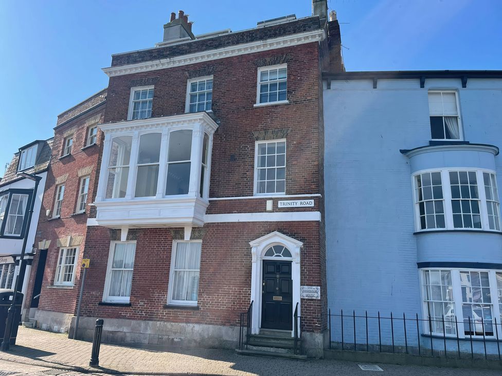 A red brick building with multiple windows and a sign on Trinity Road at Monarch Brewers Quay Harbour