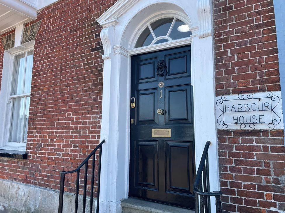 A black front door with a nameplate at Harbour House in Brewers Quay Harbour