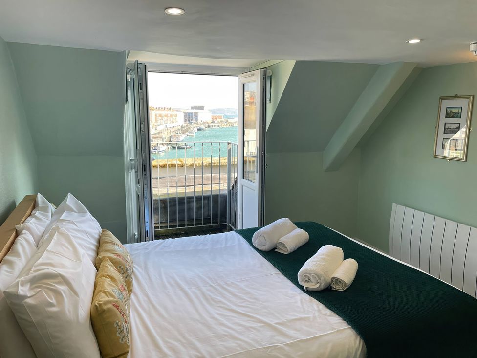 A bedroom with a bed and a view of the harbor at Monarch Brewers Quay Harbour